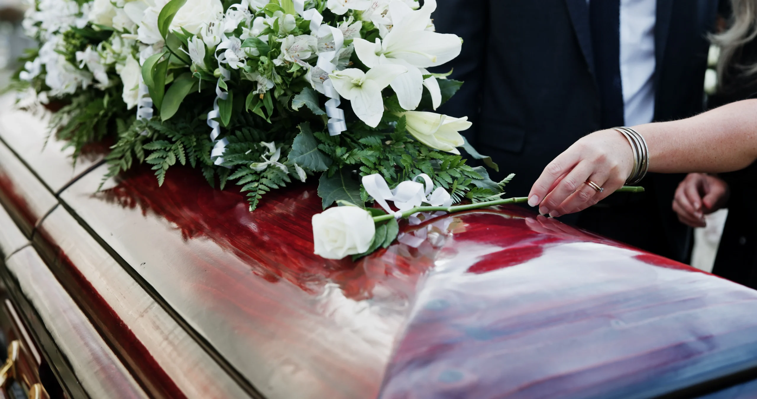 Omaggio floreale funebre con composizione di fiori bianchi sulla bara